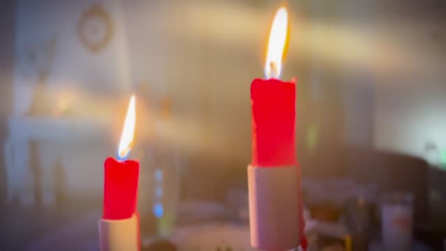 Two red burning candlelights slow rotating with shiny bokeh light animation isolated on black background, overlay texture template for festive holiday celebration4k stock video