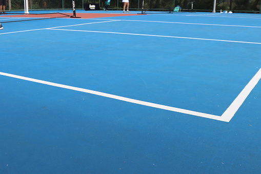 Pickleball court photo in a sunny day. Focus in the court net