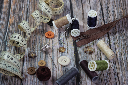Close-up of sewing accessories on a wooden background.