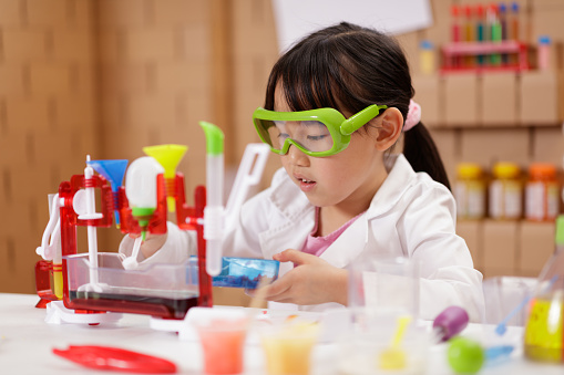 A young girl playing science experimenting at home