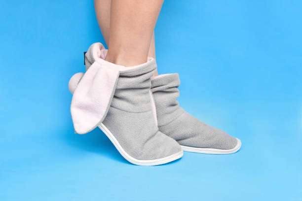 istock Female gray slippers with bunny ears on a blue background 2148627964