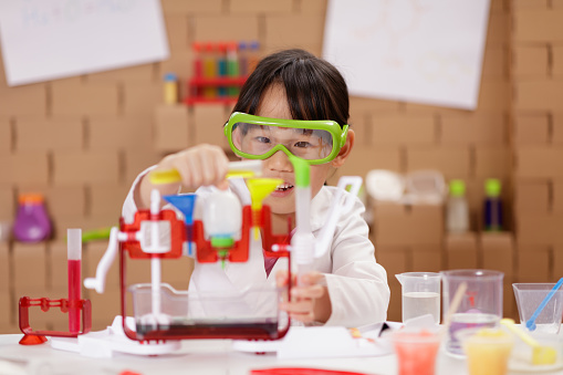 A young girl playing science experimenting at home
