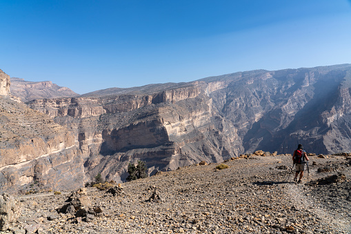 Senior men hiking the path at the edge of Oman - Grand Canyon/Wadi Nakha, rear view.