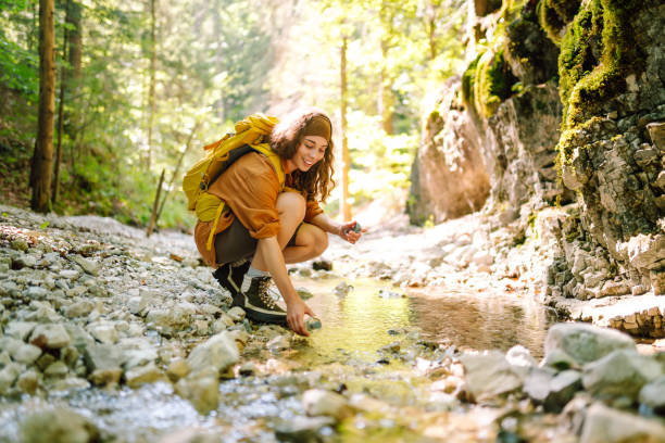 istock Woman draws clean spring water from the mountain creek. 2148629666