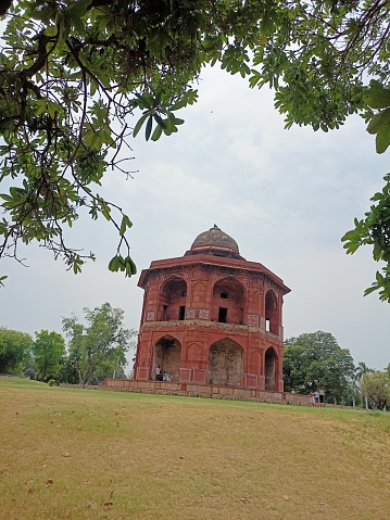 Catching a far view of the Sher mandal structure in old fort Delhi surrounded by garden and trees.