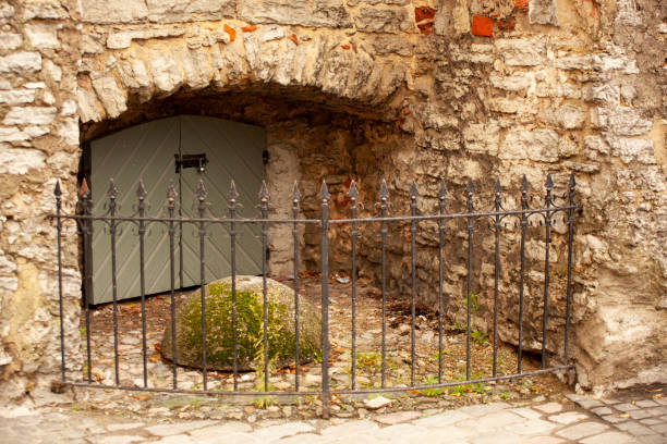 istock A secret passage in the wall behind a locked gate and wicket. Horizontal. 2148630889