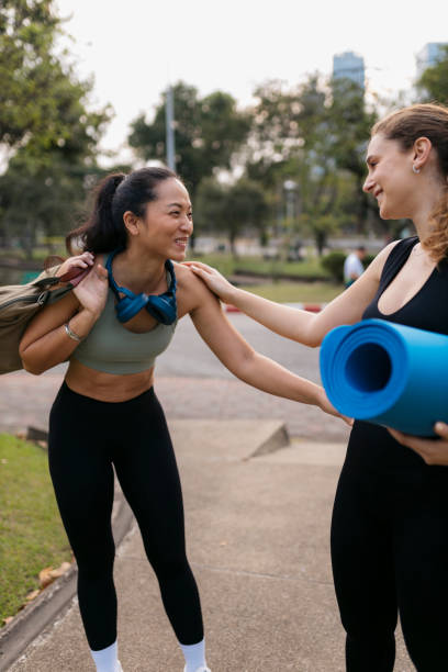 istock Two women greeting each other while arriving at park for morning workout 2148633013