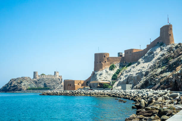 vista para os castelos arábicos al mirani e al jalali de pé sobre as rochas, mascate, omã - jalali - fotografias e filmes do acervo