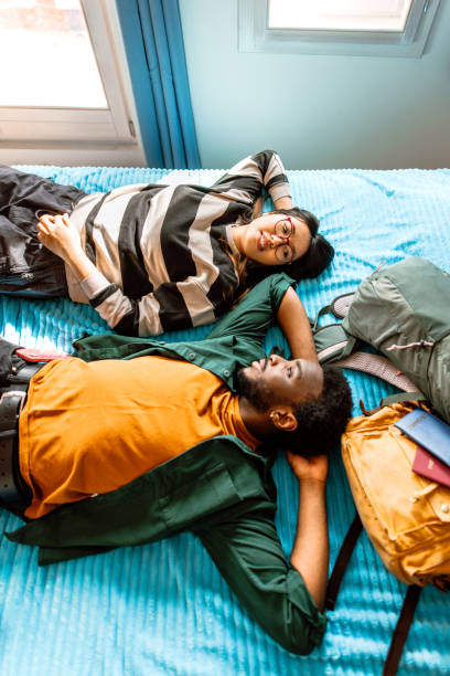 istock Young couple relaxing in bed in hotel room 2148634647