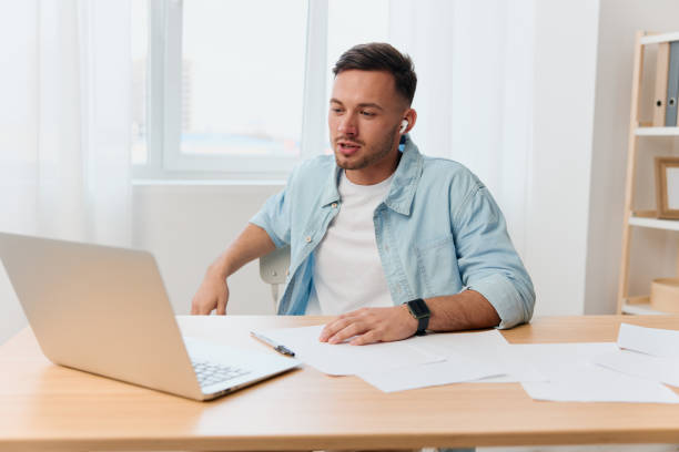 istock Smiling happy friendly good-looking young businessman conducts a job interview remotely using laptop in office. Copy space for ad. Remote Job, Technology And Career Profession Concept 2148635214