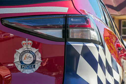 The rear and side of an Australian Federal Police vehicle parked on the street outside Admiralty House in Kirribilli, Sydney.  Admiralty House is the official residence of the Governor-General in Sydney.  This image was taken on a hot and sunny afternoon on 13 April 2024.