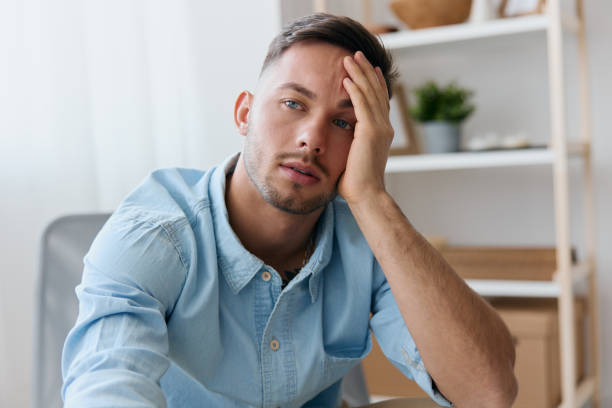 istock Sad frustrated young man reclines on hand looks aside think about difficult life decision bad news health problem. Upset guy have depression need professional psychology help. Copy space for ad 2148635266