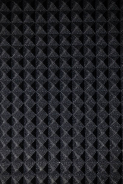 istock Background of sound absorbing sponge. Wall soundproofing. Pyramid style padding layer panel for voice recording. Lighting from below 2148635493