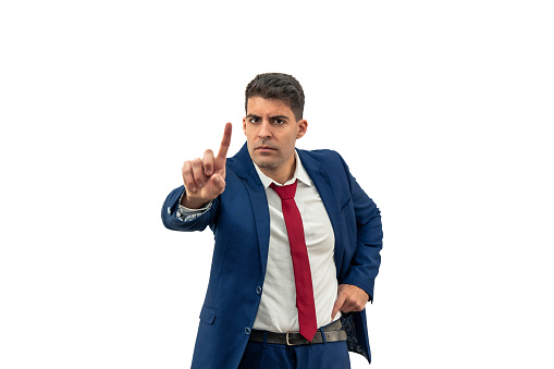 displeased expression of a businessman as he looks contrarily at the camera, with a furrowed brow, shaking his head and raising a finger in denial, expressing frustration and anger white background