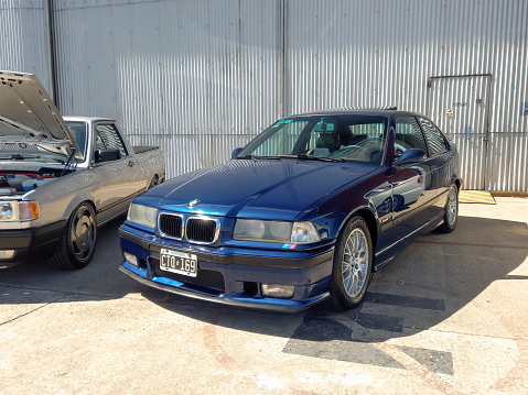 Morón, Argentina - Apr 7, 2024: Old shiny blue 1990s BMW M3 coupe at a classic car show in an airfield. Copy space