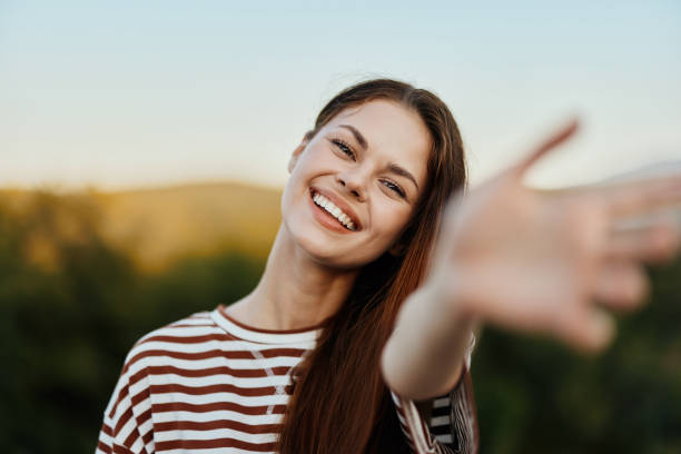 istock Woman smiling while looking at the camera and pulling her hands to the camera close-up in nature with a view of the mountains. Happy travel lifestyle follow me 2148640212
