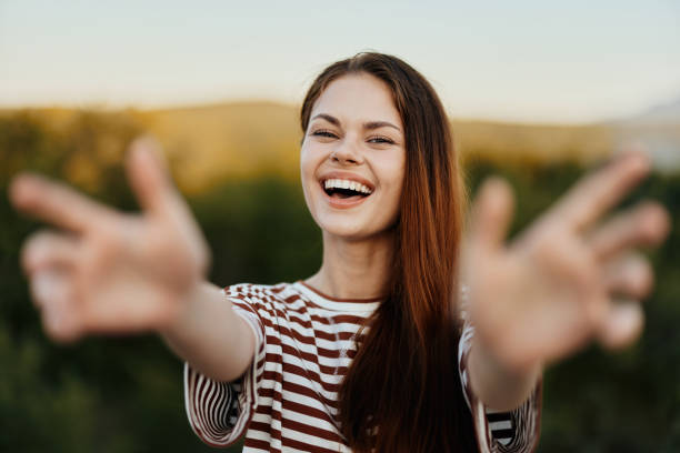 istock Woman smiling while looking at the camera and pulling her hands to the camera close-up in nature with a view of the mountains. Happy travel lifestyle follow me 2148640455