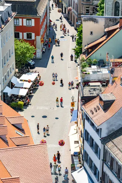 Description: View from the cathedral to the old town alley crowded with tourists on a sunny summer day. Wessenberggasse, Constance, Lake Constance, Baden-Württemberg, Germany, Europe.