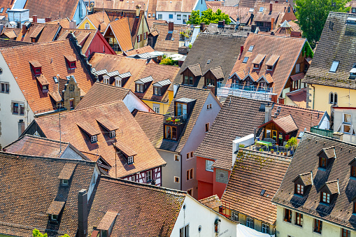 Description: View over the roofs of the old town houses with the many dormers, windows and roof terraces on a sunny summer day. Wessenbergstraße, Constance, Lake Constance, Baden-Württemberg, Germany, Europe.