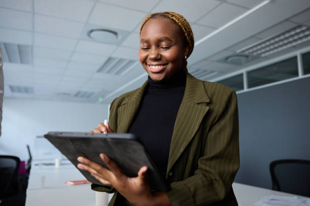istock Young businesswoman in businesswear smiling while using digital tablet and digitized pen in office 2148641751