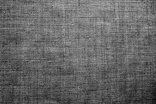 Fabric texture background. Gray fabric with weave. Natural slightly wrinkled look of the material. Uniform copy space background. Cotton, canvas or woolen thin fabric laid evenly on the surface