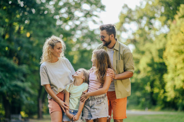 istock Happy parents hugging their daughters in nature. 2148643625