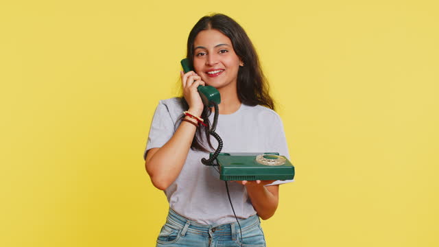 Indian woman talking on wired landline vintage telephone, advertising proposition of conversation