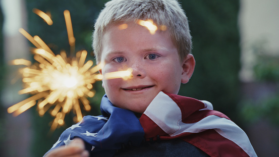 A child celebration America with a sparkler.