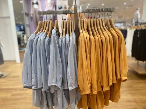 Two color T-shirts hanging in display a store