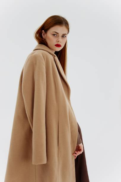 istock Professional redhead model posing on a white background in a coat. Advertising for brands showrooms catalog of clothing for women 2148647335