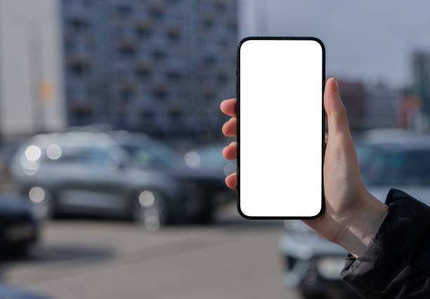 istock Hand holding mobile phone screen mock up, city background, car, building 2148647345