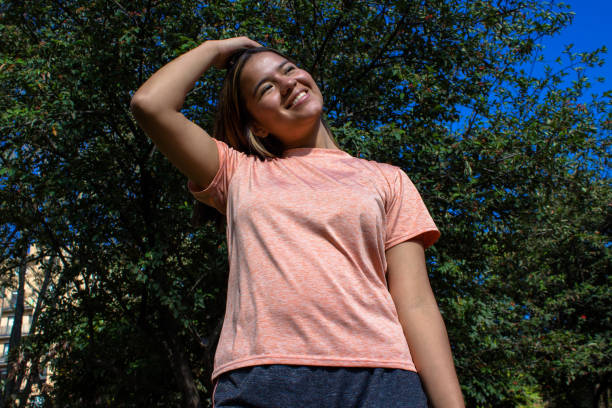 Beautiful young woman doing exercise in a public park