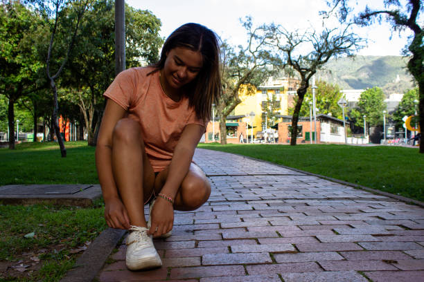 Beautiful young woman doing exercise in a public park
