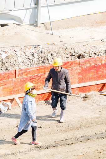 On February 29, 2024, on a sunny day in Shuangliu District, Chengdu, Sichuan Province, middle-aged workers were shoveling cement at the construction site
