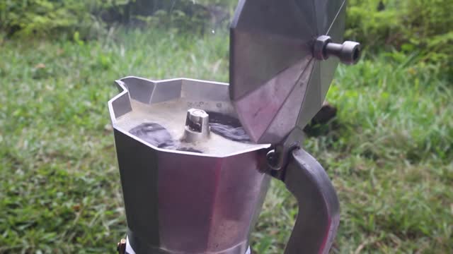 Fresh coffee being prepared in the coffee pot on the woods.