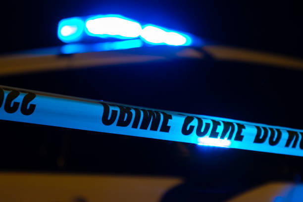 Police lights and tape during a crime scene at night.
