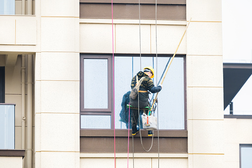 On a sunny day on March 4, 2024, in Shuangliu District, Chengdu, Sichuan Province, workers were cleaning windows on high-altitude exterior walls at a construction site