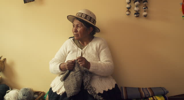 A Bolivian woman Knitting Wool at home