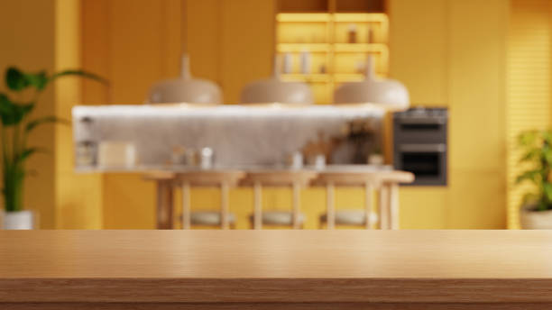 Wooden table top on blur kitchen room background,yellow kitchen room- 3D rendering