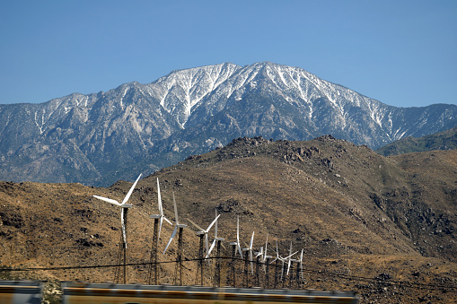 A snapshot of wind turbines with San Jacinto Peak towering above them in Riverside County, California.