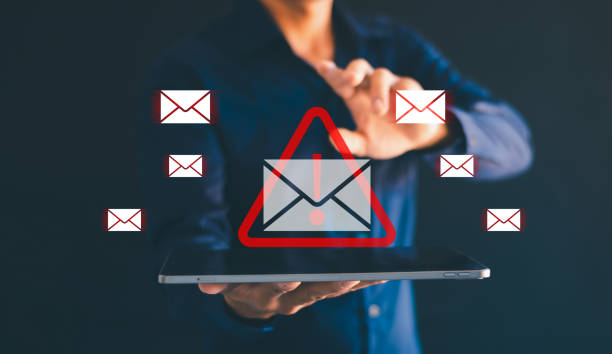 istock Male hand using tablet with spam email icon Mobile spam links Email icon virus on smartphone virtual screen holographic technology theme. Hacke 2148658270