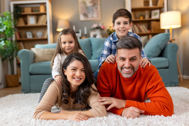 istock Happy parents and their small kids talking while lying on carpet at home. 2148662350