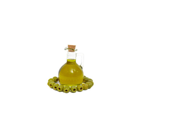 Olive oil bottles and tin cans with blank labels in various shapes and colors, along with fresh olives in a bowl