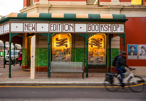 Exterior of New Edition Bookshop with cyclist riding by. Fremantle, Western Australia.