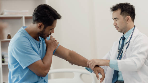 istock Physical therapist helping a patient while stretching his legs on a bed in a clinic or hospital. Young man attends a physiotherapy course on muscle weakness pain. and heel pain with elastic 2148664393