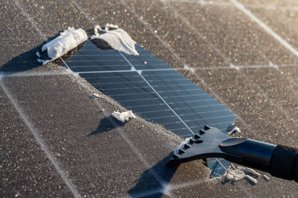 istock Balcony power plant is cleared of ice with an ice scraper for more efficient power generation 2148665780
