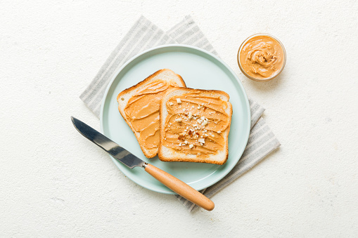 Peanut butter sandwiches or toasts on light table background.Breakfast. Vegetarian food. American cuisine top view vith copy space.