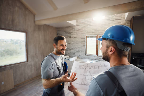 istock Happy worker talking about housing plan with his colleague at construction site. 2148666084