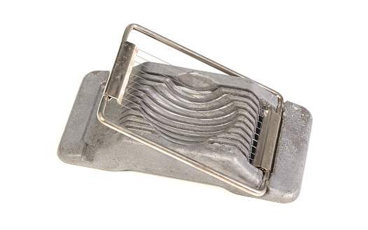 Very old egg cutter isolated on a solid background