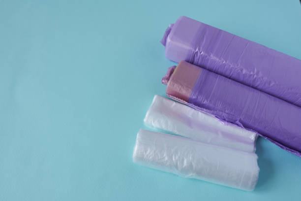 istock Rolls of clear and purple polyethylene trash bags on a blue background. 2148666146